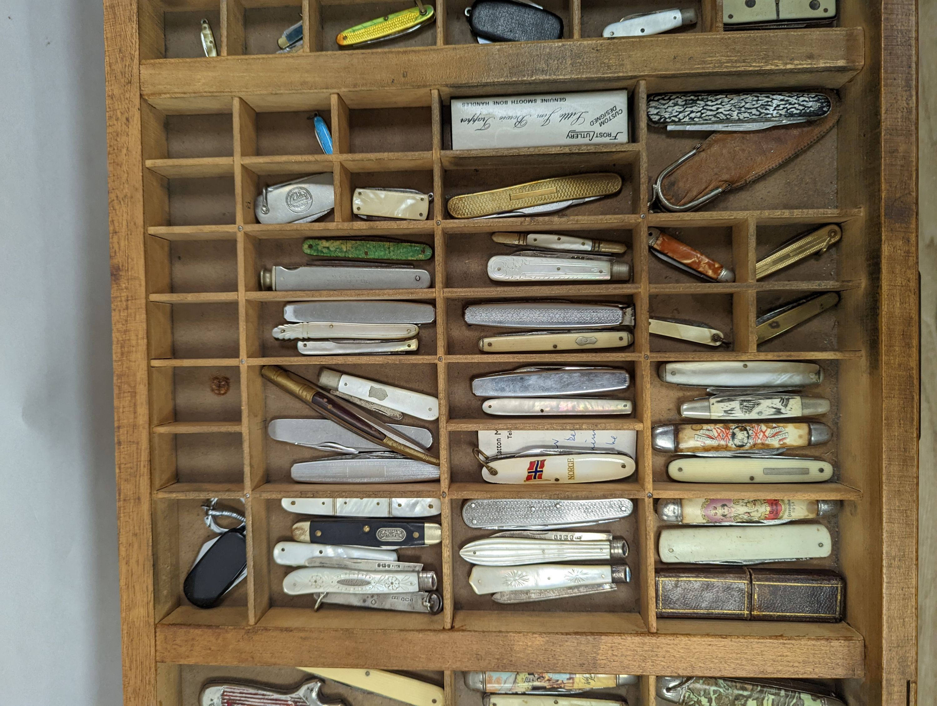 A collection of 19th century and later pen and fruit knives mounted in a coffee table